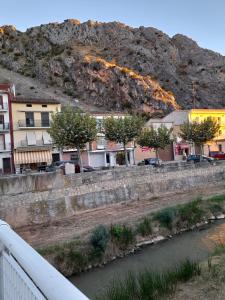 eine Brücke über einen Fluss mit einem Berg im Hintergrund in der Unterkunft Camino a Monasterio de piedra in Alhama de Aragón