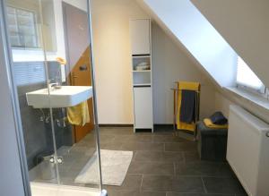 ein Badezimmer mit Waschbecken und Glasdusche in der Unterkunft Daun Under in Daun