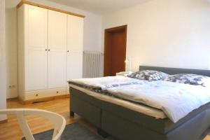 ein Schlafzimmer mit einem großen Bett und einem weißen Schrank in der Unterkunft Daun Under in Daun