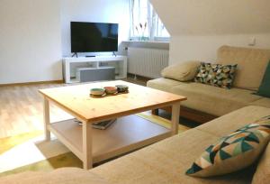 a living room with a coffee table and a television at Daun Under in Daun