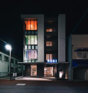 um edifício com uma fachada iluminada à noite em NAGI Hiroshima Hotel and Lounge em Hiroshima