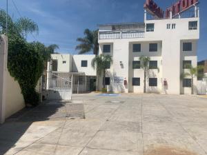 un parking vide devant un bâtiment blanc dans l'établissement Hotel Arbis, à Puebla