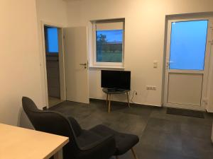 a living room with a television and a table and chairs at Monteurwohnung 1 in Ingelheim am Rhein