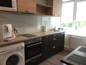 a kitchen with a washing machine and a microwave at K.G. Apartment in Ventspils