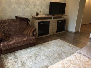 uma sala de estar com um sofá e uma televisão de ecrã plano em K.G. Apartment em Ventspils