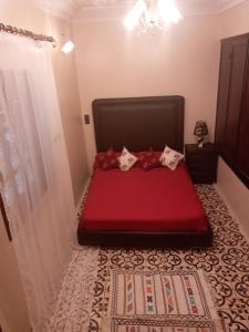 a bedroom with a red bed in a room at chambre priver in Rabat