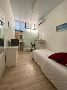 a bedroom with a bed and a desk and a refrigerator at Pousada Thiany in Bento Gonçalves