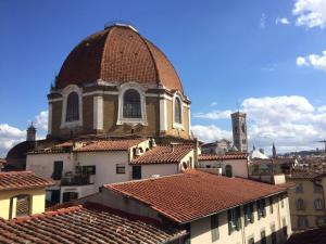 una iglesia con techo rojo en la parte superior de los tejados en Luxury Home Florence terrazza vista Firenze, en Florencia