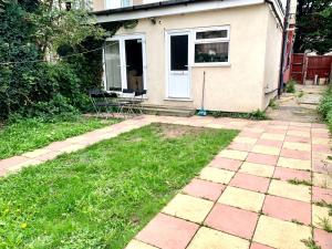 a house with a patio and a yard with grass at 4 Bedrooms, 3 Baths, Full Kitchen and Lounge, Garden, Free Parking in London