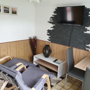 ノルデンにあるFerienwohnung 1-2 Personenのテーブルと椅子、壁にテレビが備わる客室です。