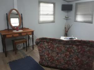 a living room with a couch and a mirror at Nadine's Self - Catering Accommodation in Stormsrivier