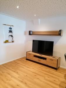 ein Wohnzimmer mit einem TV und einem Leuchtturm an der Wand in der Unterkunft Ferienwohnung Seebär in Emden