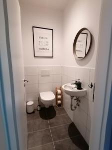 a bathroom with a sink and a toilet and a mirror at Ferienwohnung Seebär in Emden