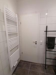 ein Badezimmer mit einer weißen Tür und einem Regal in der Unterkunft Ferienwohnung Seebär in Emden