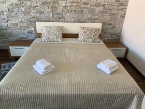 ein Schlafzimmer mit einem Bett mit zwei Handtüchern darauf in der Unterkunft Apartmán u pláže s terasou in Pavlov