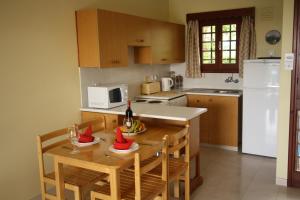 a kitchen with a table and chairs with a bottle of wine at Maria Villa in Pissouri +24 photos