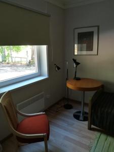 a room with a desk and a table and a window at Remniku Holiday Centre in Remniku