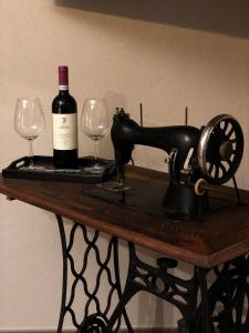 een fles wijn en twee glazen op een tafel bij Rooms Da Steu in Barbaresco
