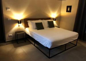een slaapkamer met een groot bed met 2 lampen erop bij Rooms Da Steu in Barbaresco