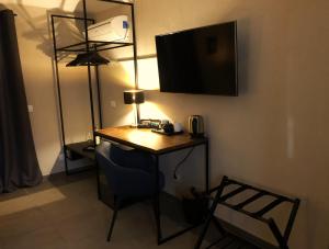a room with a desk with a phone and a lamp at Da Steu Rooms in Barbaresco