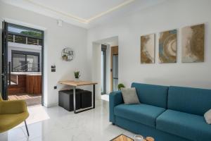 een woonkamer met een blauwe bank en een tafel bij Nectar Luxury Residence in Kissamos