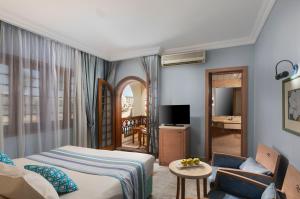 Royal Lagoons Resort & Aqua Park Families and Couples Only في الغردقة: غرفة نوم مع سرير وغرفة معيشة