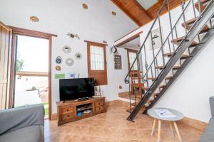 ein Wohnzimmer mit einem TV und einer Treppe in der Unterkunft Casa la Orilla in Antigua
