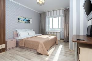 a hotel room with a bed and a television at ПЕНТХАУС 110 м2 в САМОМ ЦЕНТРЕ ЯРОСЛАВЛЯ in Yaroslavl