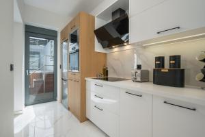 - une cuisine avec des armoires et des appareils blancs dans l'établissement Nectar Luxury Residence, à Kíssamos