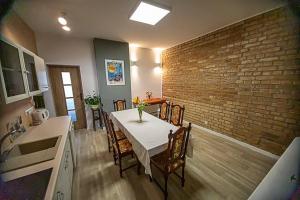 a kitchen with a table with chairs and a brick wall at apartament Rynek in Leśna