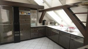 uma cozinha com armários castanhos, um lavatório e uma janela em Penthouse Himmelreich großzügige Maisonette auf 152 qm mit Klima & Kamin em Senftenberg