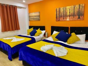 two beds in a room with yellow and blue at London Luxury 2Bedrooms, Reception, Garden, Apartment in Ilford
