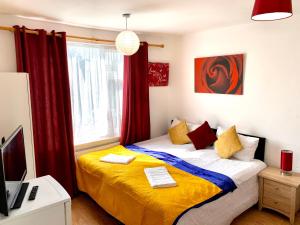 - une chambre avec un lit doté de rideaux rouges et d'une fenêtre dans l'établissement London Luxury Apartment, Private Bathroom, à Ilford