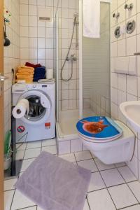 a bathroom with a toilet with a dog on the lid at Ferienwohnung Big Family in Ichenhausen