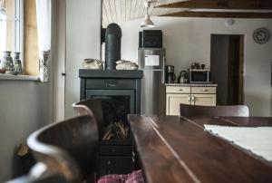 a dining room with a table and a fireplace at Ve Stodole in Zlatá Olešnice