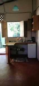 a kitchen with a table and a sink in a room at Casa Arlecchino in Puerto Viejo