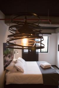 un lampadario pendente appeso sopra un letto in una stanza di The Coffee Club a Manizales