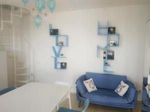 um quarto com uma cadeira azul e uma mesa branca em AMPHIORAMA em La Spezia