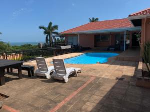 a patio with two chairs and a table and a pool at Seaview Executive Guest House in Mtunzini