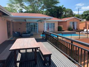 a deck with a picnic table and a pool at Seaview Executive Guest House in Mtunzini