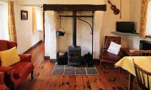 una sala de estar con estufa de leña. en Rosies Cottage, en Maghera