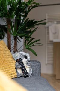 un animal farci assis sur un canapé avec télécommande dans l'établissement Koaloft, à Lorient