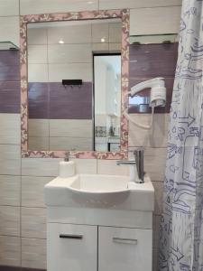 een badkamer met een wastafel en een spiegel bij 7. Luxurious sea view rooftop suite in the center! in Rhodos-stad