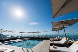 a pool with chairs and umbrellas on a building at PortoBay Rio de Janeiro in Rio de Janeiro