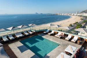uma piscina ao lado de uma praia com guarda-sóis em PortoBay Rio de Janeiro no Rio de Janeiro