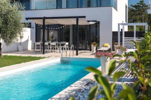 a swimming pool in front of a house at Villa Benić in Crikvenica