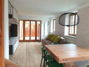 sala de estar con mesa y sofá en Ampio appartamento su 2 livelli con garage coperto, en Valdaora
