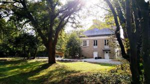 une vieille maison avec un arbre dans la cour dans l'établissement KastellRen - Maison d'hôtes, à Rennes