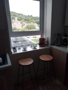two stools in front of a window with a view at Apartment in the heart of Callander in Callander