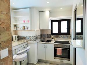 a white kitchen with a sink and a stove at 7. Luxurious sea view rooftop suite in the center! in Rhodes Town